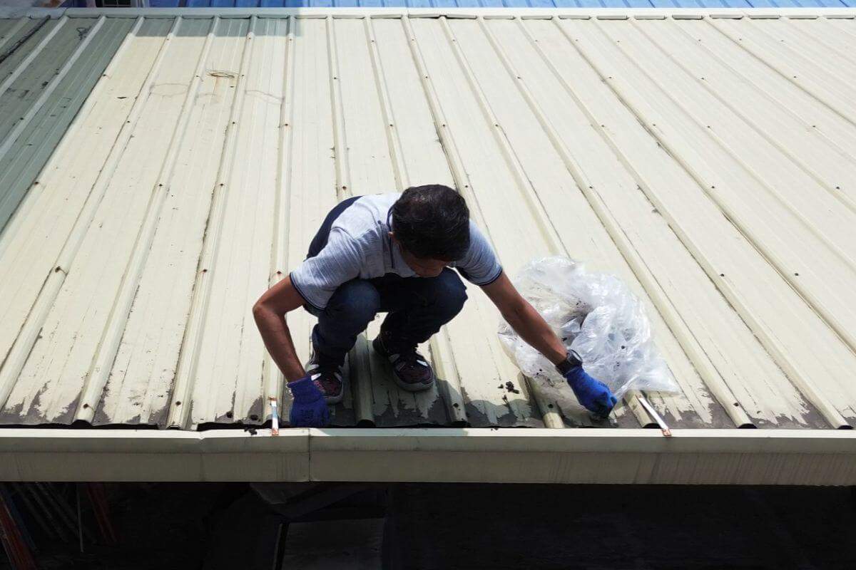 Professional cleaning out the gutters of a roof