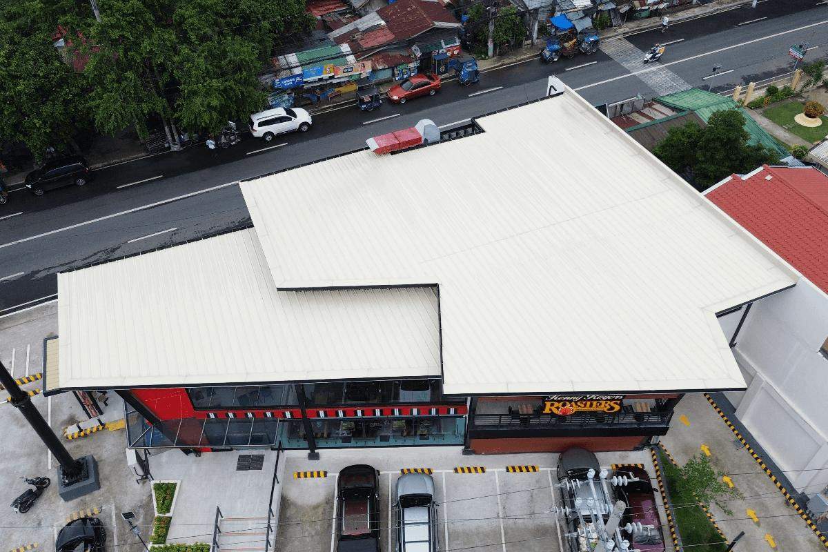 Aerial view of a commercial building with a light-colored insulated metal roofing system installed on top
