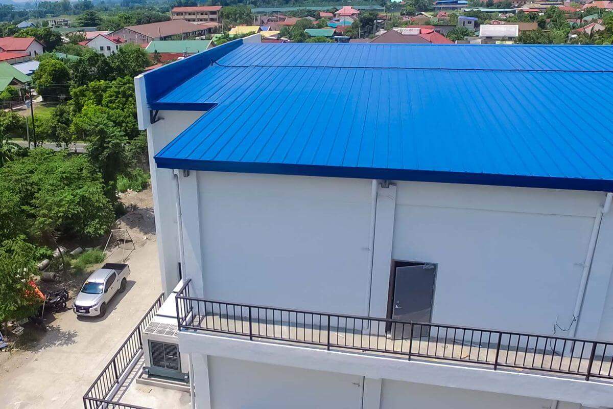 Close-up aerial view of a blue insulated metal roof on a commercial building